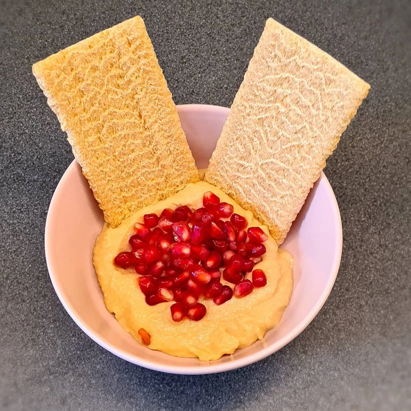 Krēmīgs humuss ar granātābolu un maizes plāksnītēm