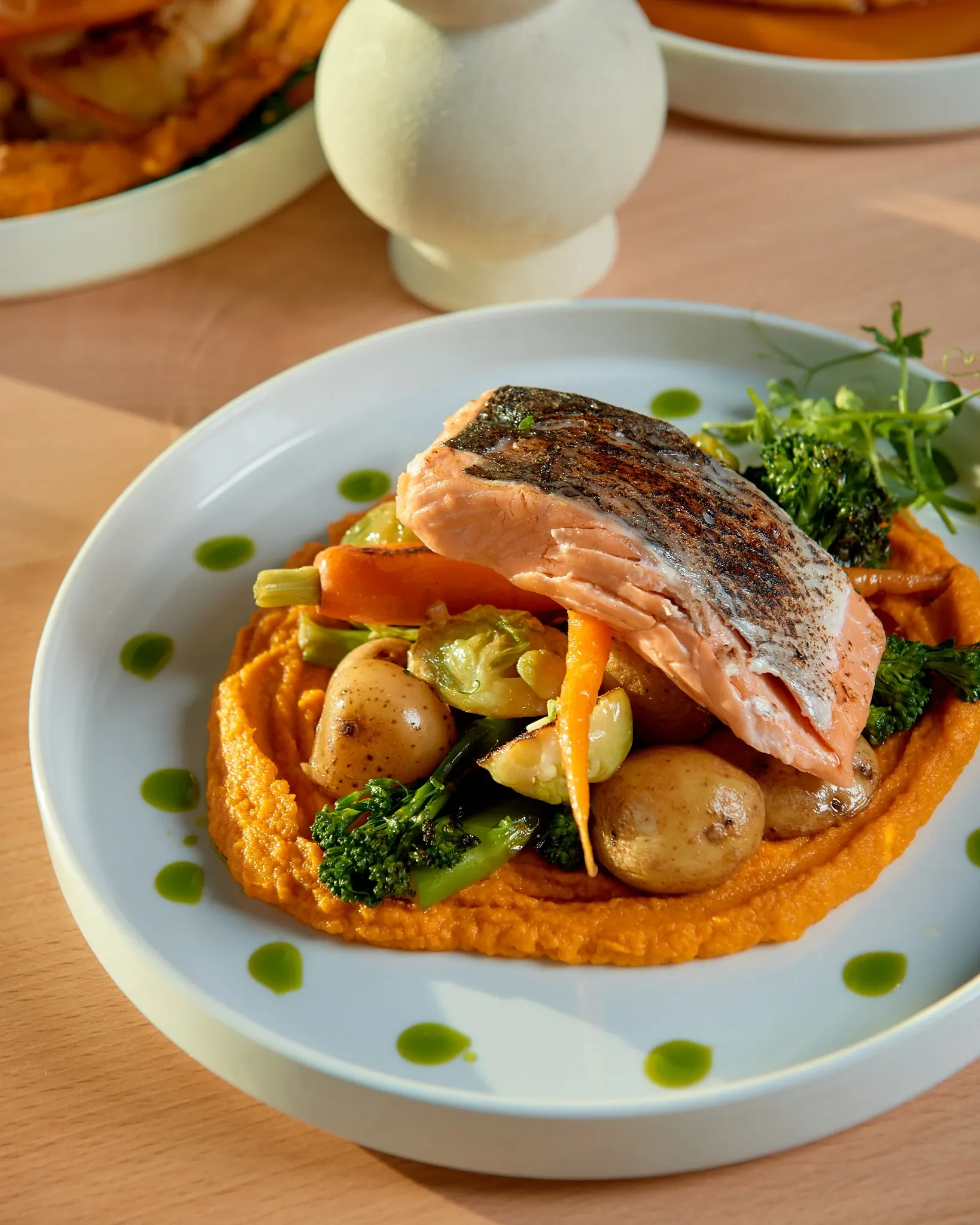 Łosoś podany z młodymi ziemniakami, musem z marchewki i starannie dobranymi warzywami