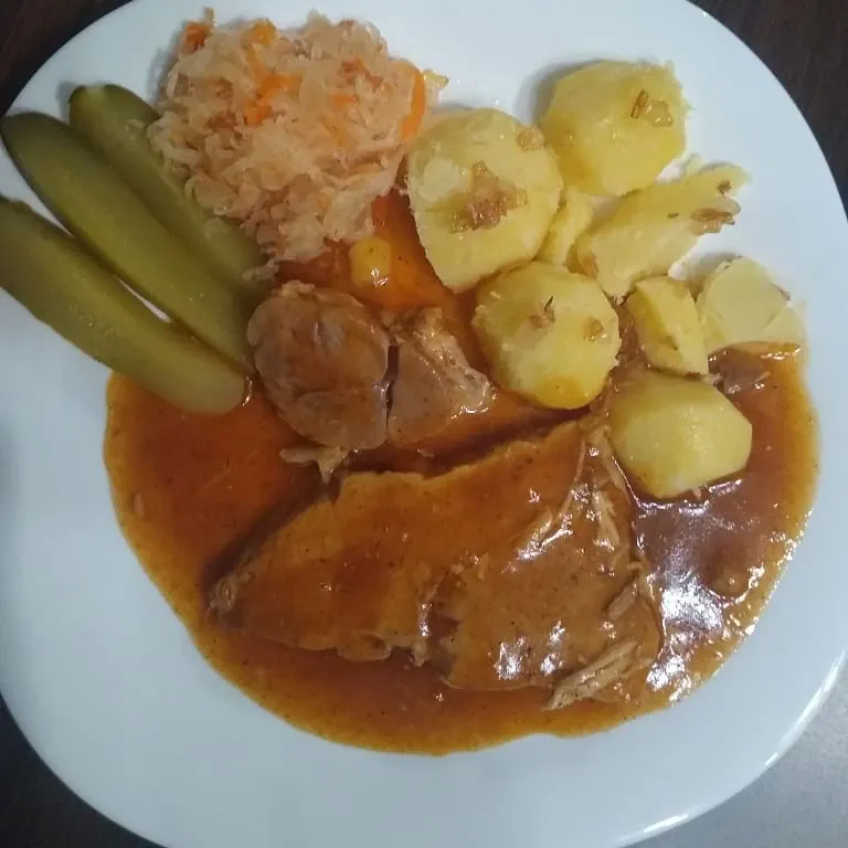 Szynka pieczona w plastrach z ziemniakami, sosem pieczeniowym i dodatkami