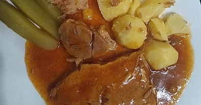Szynka pieczona w plastrach z ziemniakami, sosem pieczeniowym i dodatkami