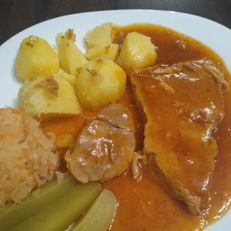 Szynka pieczona w plastrach z ziemniakami, sosem pieczeniowym i dodatkami