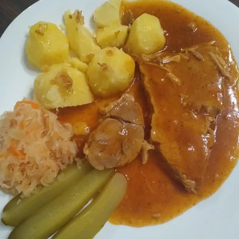 Szynka pieczona w plastrach z ziemniakami, sosem pieczeniowym i dodatkami