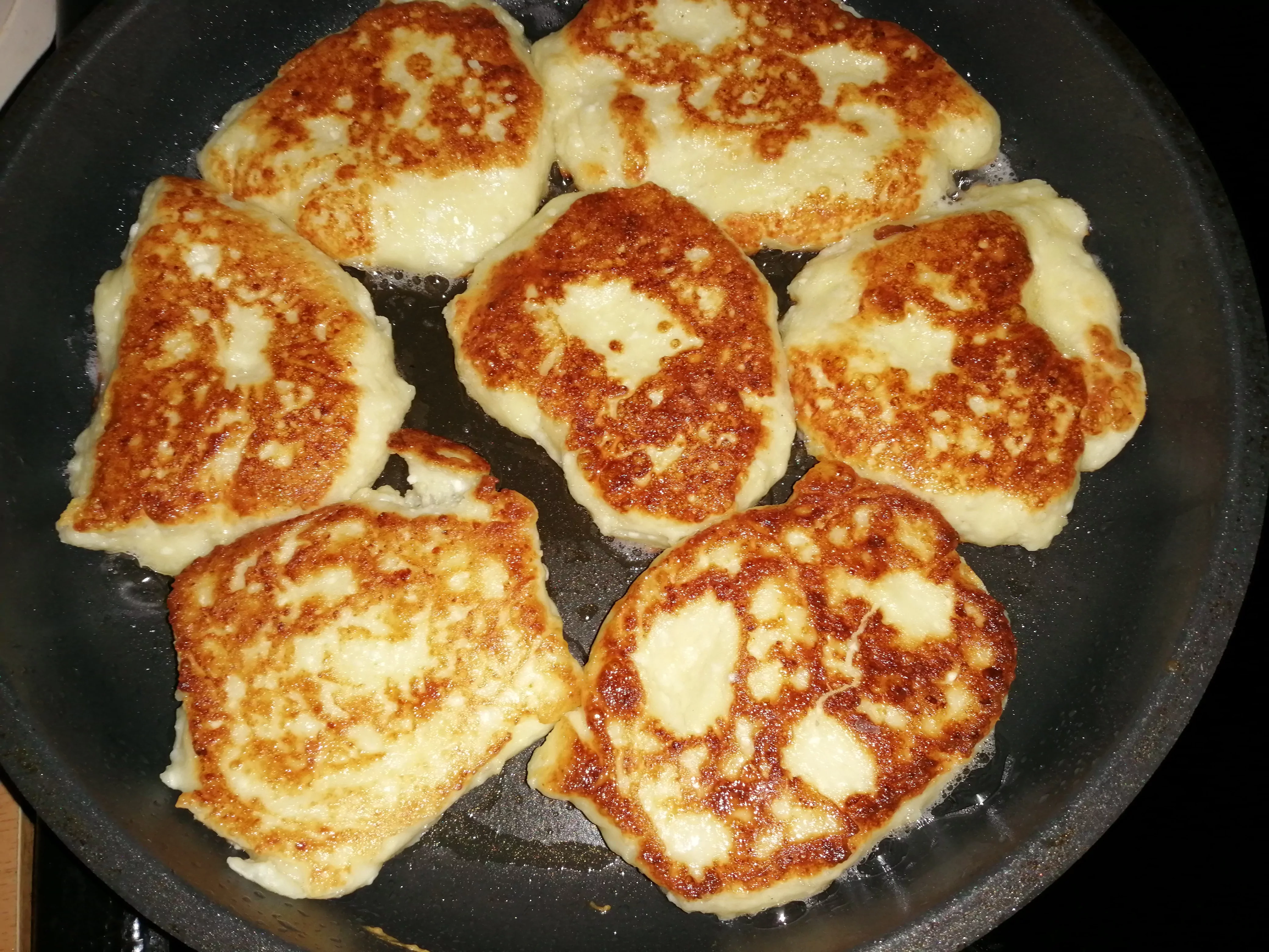 Močiutės senoviniai minkšti, purūs tikri kepti varškėčiai keptuvėje su grietine