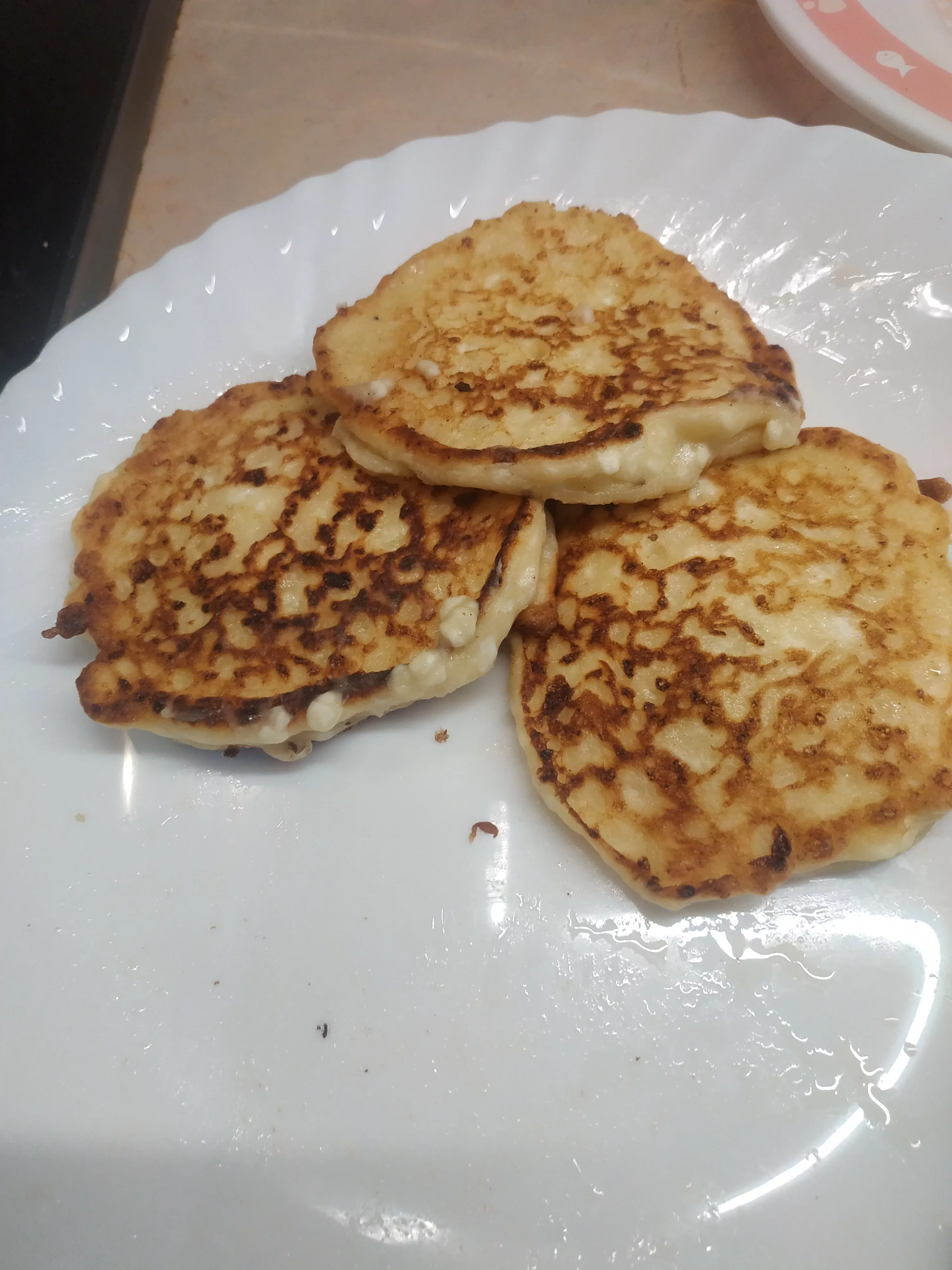 Močiutės senoviniai minkšti, purūs tikri kepti varškėčiai keptuvėje su grietine